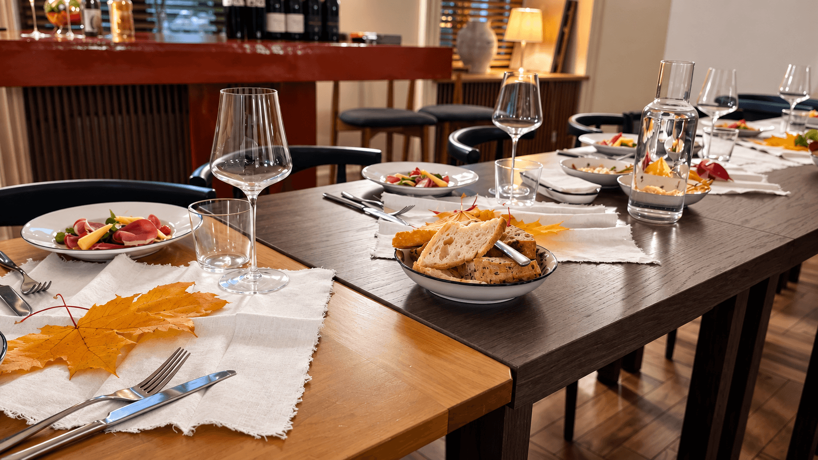Сервированный стол в Cazaban Bistro & Bakery с бокалами, закусками, хлебом и осенним декором из кленовых листьев