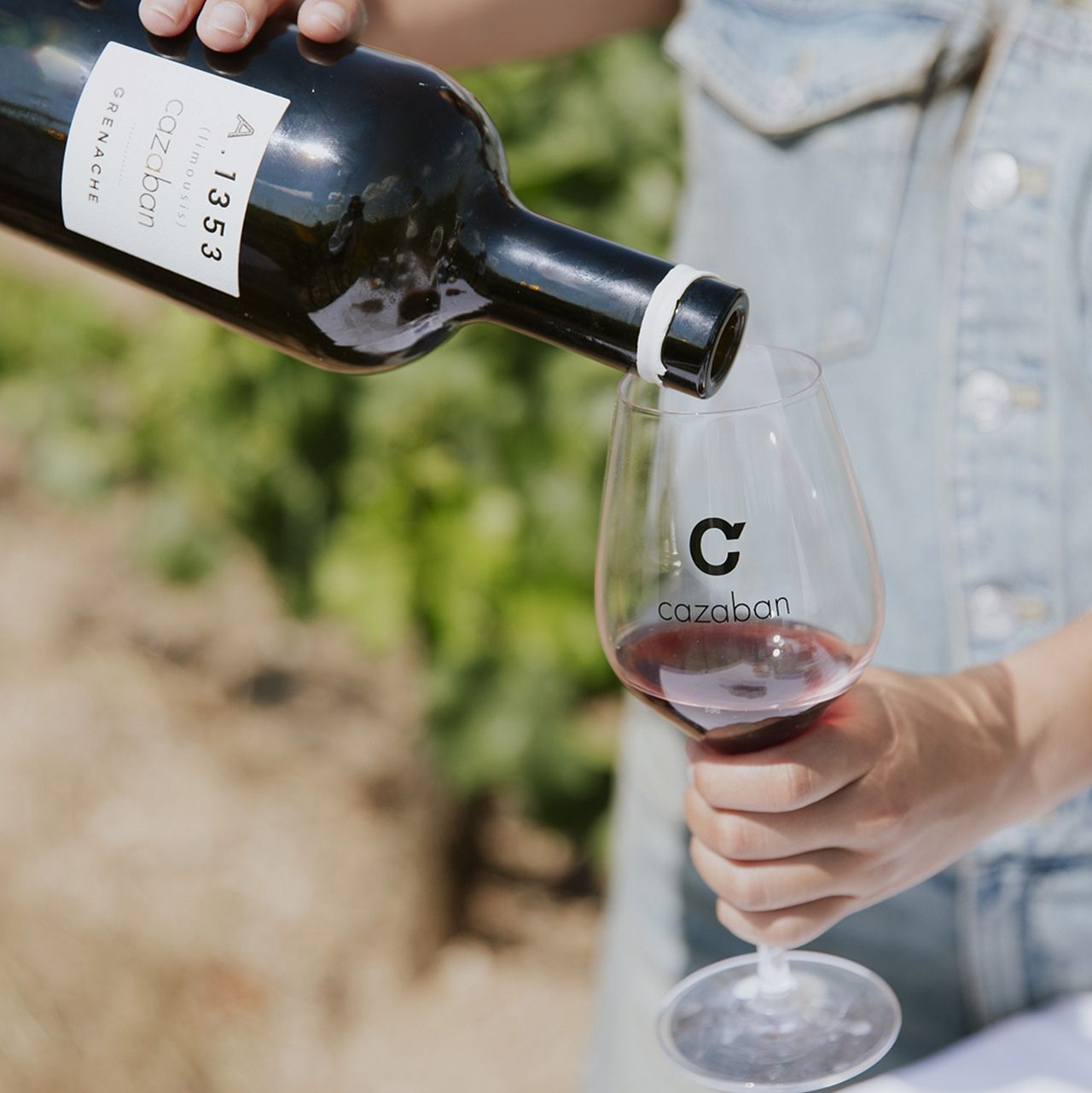 Красное вино Cazaban A1353 Grenache разливают по бокалам на винограднике
